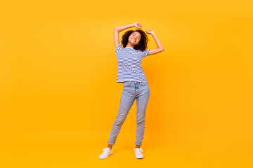 Full size photo of adorable carefree girl closed eyes raise hands isolated on yellow color background