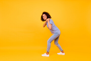 Fototapeta na wymiar Full length profile portrait of positive excited person arms pull hold carry empty space isolated on yellow color background