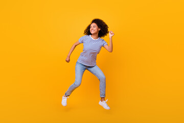 Fototapeta na wymiar Full body portrait of overjoyed cheerful sporty lady jump run hurry fast isolated on yellow color background