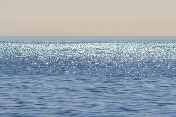 View of the open sea. Bright sun glare on the surface of the water. Minimalist seascape. Beautiful...