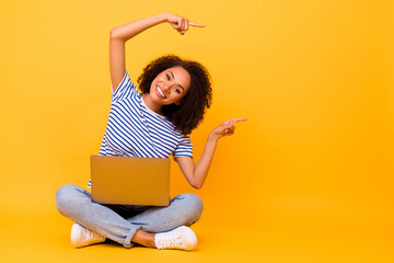 Full body portrait of attractive positive girl indicate fingers empty space use netbook isolated on...