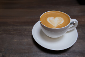 cup of cappuccino coffee with latte art on a dark wooden table with copy space. coffee lover, take a break concept