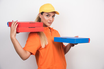 Delivery woman with yellow hat holding pizza boxes on white background
