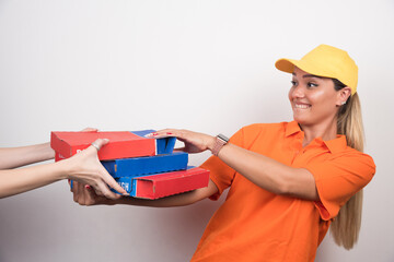Pizza delivery woman delivering pizza boxes to customer on white background