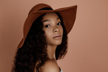 Close up portrait of young female in hat. Clean skin. Healthy care. Beautiful African American in hat. Studio shoot. 