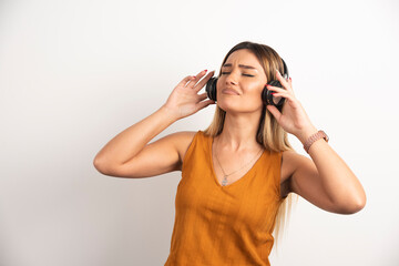 Young beautiful woman wearing headphones over white background