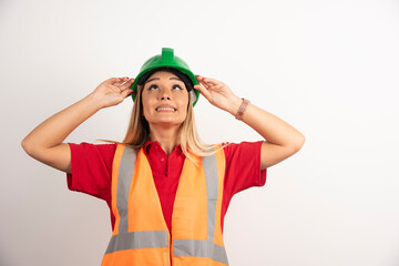 Employee woman in a vest and protective helmet on white background