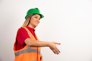 Smiling woman in protective uniform and helmet posing on white background