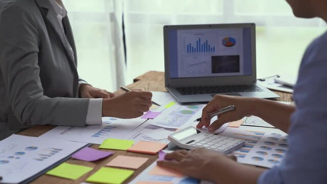Financial analyst analysis business financial report on graph document and laptop during a discussion at corporate showing the results of their successful teamwork, business meeting concept, Marketing
