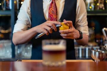 Professional male bartender preparing and serving cocktail drink to customer on bar counter at...