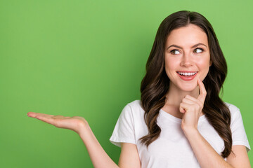 Photo of pretty tricky woman dressed white t-shirt finger chin holding arm looking empty space...