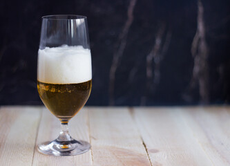 Glass of the light beer on dark background