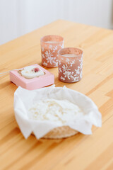Natural soap lies on wooden table. Candles Peach color with star ornament.