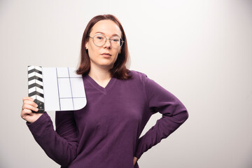 Young woman posing with a cinema tape on a white background