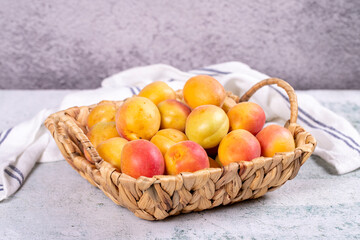 Fresh apricots. Ripe apricots in a basket on a stone background. Bulk apricots. close up