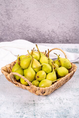 Fresh pear. Ripe pears in a basket on a stone background. Bulk pear. close up