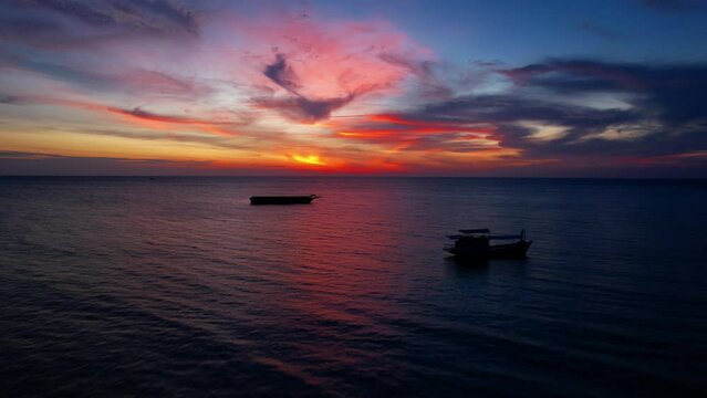 Colorful sunset twilight atmosphere in full tropical sea with boats silhouettes, Thailand