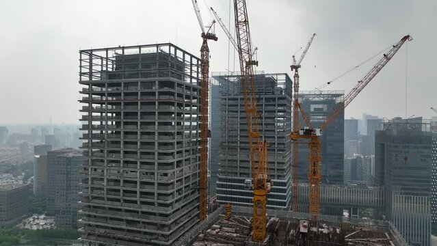 Building in construction in city, crane around. Drone aerial view. Construction site aerial view of downtown city Shanghai China.  Industry, business, house development concept concept b-roll footage.
