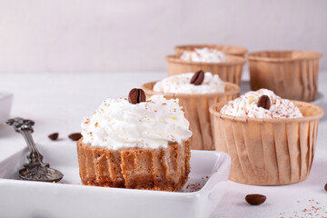 Mini cheesecake with cappuccino taste topped with whipped cream and coffee bean. Portion size dessert
