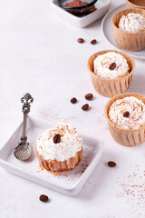 Mini cheesecake with cappuccino taste topped with whipped cream and coffee bean. Portion size dessert