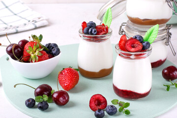 Whipped cottage cheese dessert with jam in the jar topped with berries. Healthy breakfast
