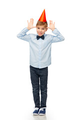 birthday, childhood and people concept - portrait of smiling little boy in party hat and bowtie making faces over white background