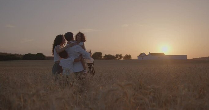 happy family taking pictures in the field at sunset