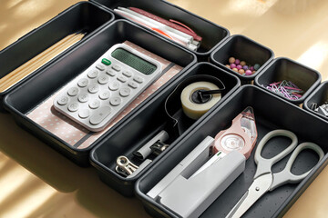Stylish  stationery  is arranged in black organizers. Creative Drawer Organizing. Storage office supplies.