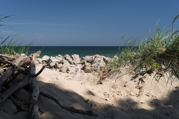 SEA COAST - Dune and rocks strengthening shore with sea in the background
