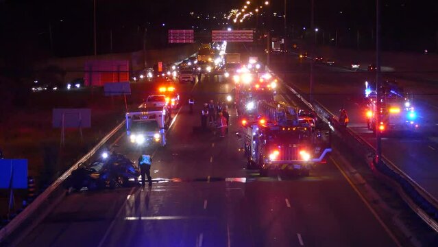 paramedics team attending a three-vehicle collision on overnight crash on the Queen Elizabeth Way in Mississauga, Canada, at June 16