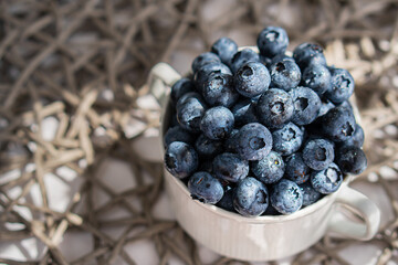 Water drops on ripe blueberries in small white dish