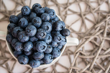 Water drops on ripe blueberries in small white dish
