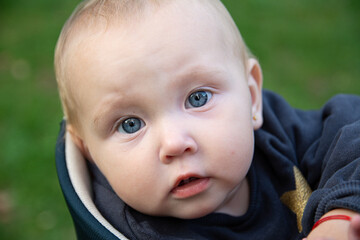 Portrait of a beautiful baby girl. The baby looks into the camera with beautiful blue eyes.