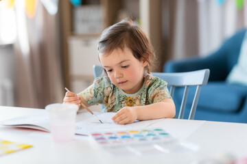 childhood, art and leisure concept - little baby girl drawing at home or kindergarten