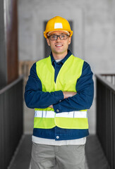 architecture, construction business and building concept - happy smiling male architect in helmet and safety west at office
