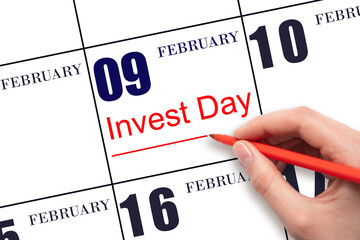 Hand drawing red line and writing the text Invest Day on calendar date February 9. Business and financial concept.