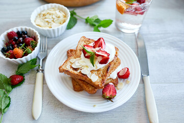 Breakfast of french toast with strawberries and maple syrup, good morning..
