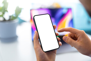Man using smartphone blank screen frameless modern  - bright colorful home interior