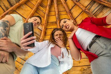 Group of young people and couples taking selfies in nature and smiling