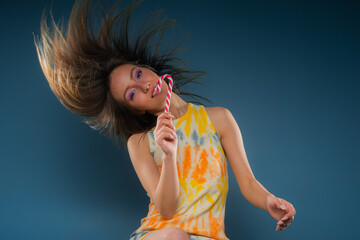 Flipping her hair in studio on blue background