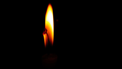burning candle on black background