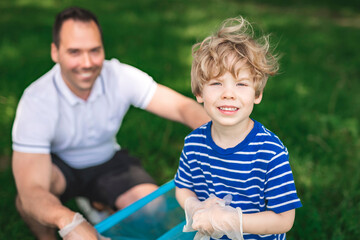 father and boy recycling outdoors together on a summer day at the parc
