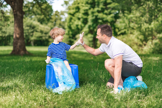 father and boy recycling outdoors together on a summer day at the parc