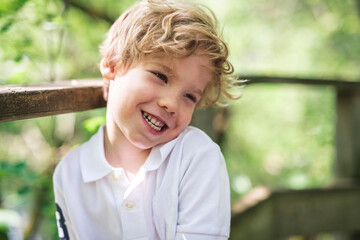 boy along in summer park. Child in green woods