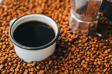 Taza de café con granos de café tostado con una cafetera al lado. Concepto de alimentos.