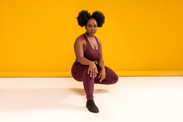 Obraz premium Happy plus size woman posing in sporty black fashionable clothes, smiling to the camera. Sports and weight loss concept. Full length photo.