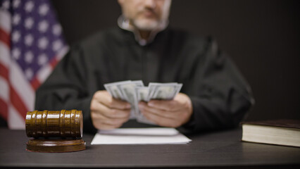 Corrupt male judge counting money before hitting hammer, flawed judicial system