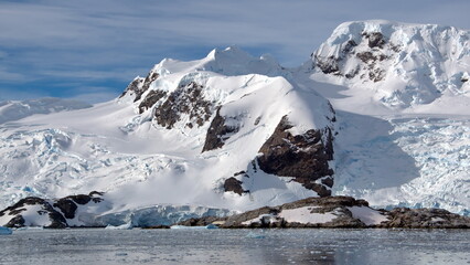 Icebergs at the base of a snow covered mountain at Cierva Cove, Antarctica