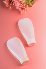 White cosmetic product in tubes on color background. Mock up skincare cosmetic package on pink.