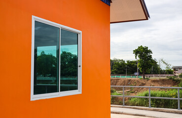 An exterior side view of a house with beautiful orange walls.